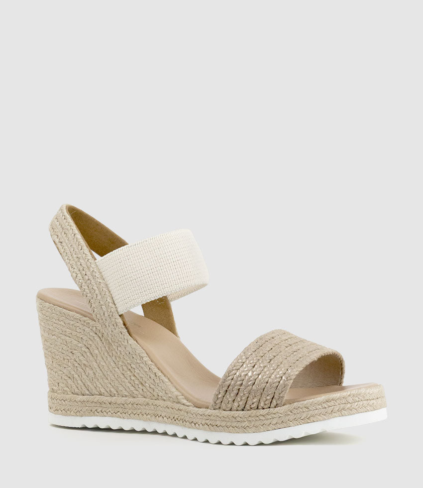 Beige wedge sandal with espadrille sole on a light gray background