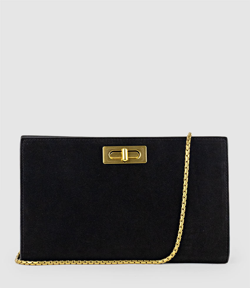 Black suede NAYLA clutch bag by Edward Meller with gold chain and clasp on a light gray background