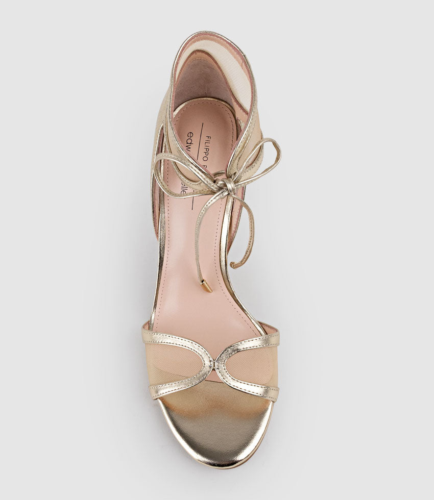 Gold high-heeled sandal with lace-up design on a light gray background